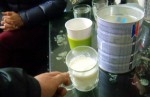 Sữa Abbott Grow được chị Hạnh lấy từ trong hộp pha vào cốc có sự chứng kiến của 2 nhân viên bảo vệ khách hàng.