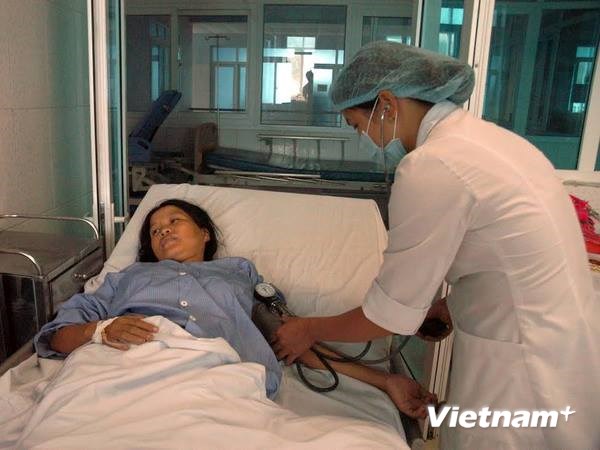 Bác sỹ cấp cứu cho một sản phụ bị ngộ độc. (Ảnh: Công Hải/Vietnam+)